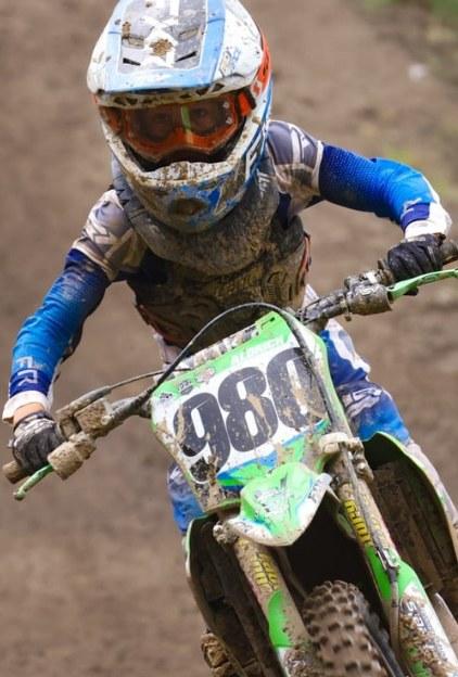 Tucker Aldrich #980 on the Kawasaki, mud-spattered mid-moto